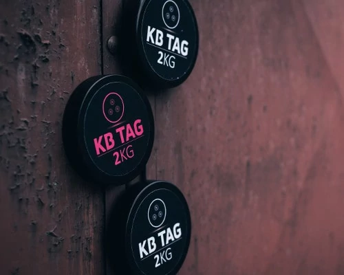 Tři KB TAGy držící magnety na kovových dveřích